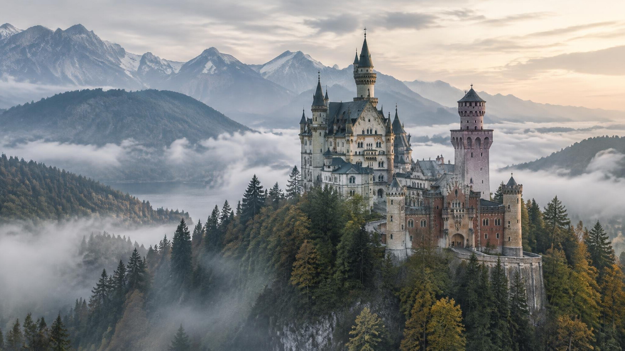Fairytale Bavarian castle on a forested hill surrounded by mist